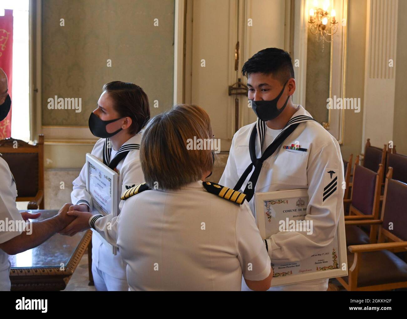 210517-N-UJ449-1061 BELPASSO, Italy (May 17, 2021) Hospitalman Donald Leal receives a coin from Capt. Denise Gechas, U.S Navy Medical Readiness and Training Command Sigonella commanding officer, during a ceremony held for rendering life saving first aid after a vehicle accident May 17, 2021. NAS Sigonella’s strategic location enables U.S., allied, and partner nation forces to deploy and respond as required, ensuring security and stability in Europe, Africa and Central Command. Stock Photo