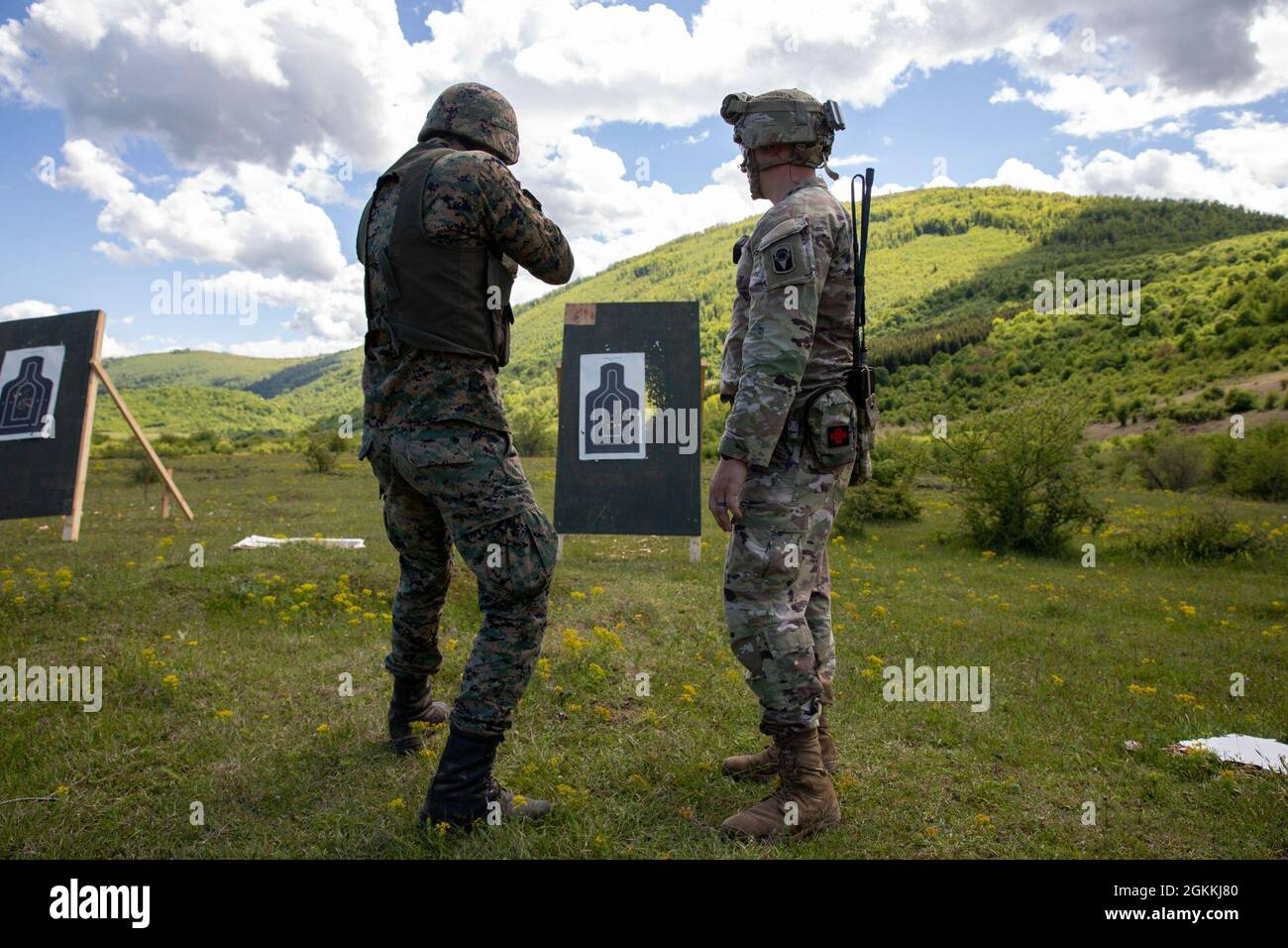 Private Amar Gluhić (front left), a military police soldier with the Bosnia and Herzegovina Armed Forces, shoots the Mossberg 500 tactical shotgun with assistance from Sgt. 1st Class Michael Kendall (front right), a platoon sergeant with 2nd Battalion, 124th Infantry Regiment, 53rd Infantry Brigade Combat Team, at Manjača Training Area, Bosnia and Herzegovina (BiH), May 18, 2021. Immediate Response 21 supports DEFENDER-Europe 21, a prime example of U.S. forces working closely with NATO allies and partners in peacetime. Together, joint forces can deter outside aggression. Stock Photo