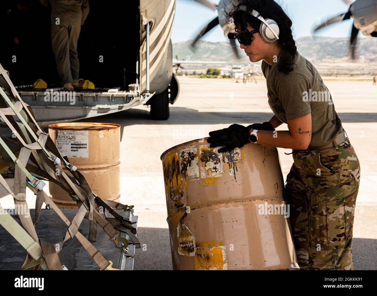 U.S. Air Force 1st Lt. Miolani Grenier, U.S. Air Forces in Europe – Air Forces Africa Intelligence, Surveillance, Reconnaissance capabilities and development deputy chief, positions a barrel underneath a cargo pallet as an alternative platform during a combat offload training scenario as part of Operation Stolen Cerberus VIII at Elefsis Air Base, Greece, May 18, 2021. Grenier supports the bilateral training event as a multi-capable Airmen (MCA) from the Cross-Functional Airlift Support Personnel (CASPER) program based at Ramstein Air Base, Germany. The CASPER program brings together teams of A Stock Photo