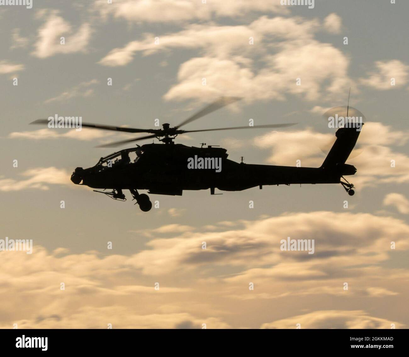 Aviators assigned to 4-6 Air Cavalry Squadron, 16th Combat Aviation Brigade, maneuver at sunset in an AH-64 attack helicopter at Yakima Training Center, Wash., on May 18, 2021.  The Soldiers conduct day and night gunnery training. Stock Photo