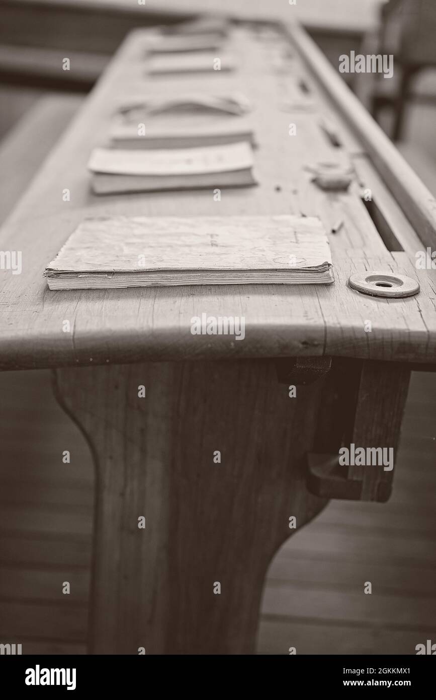 Vintage wooden student form desk with inkwell and books as used in a ...
