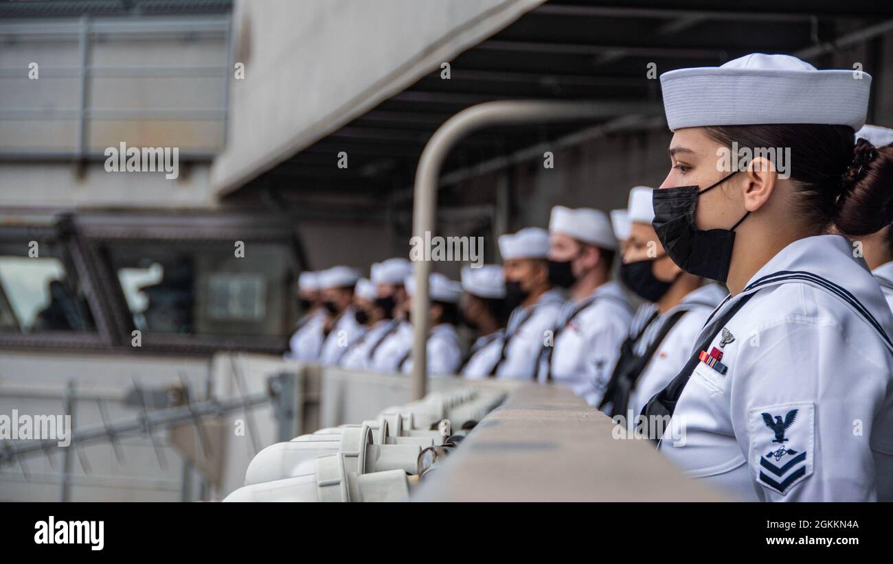 210519-N-WS494-1110 YOKOSUKA, Japan (May 19, 2021) Sailors man the rails aboard the U.S. Navy’s only forward-deployed aircraft carrier USS Ronald Reagan (CVN 76) as it departs Commander, Fleet Activities Yokosuka, Japan. Ronald Reagan, the flagship of Carrier Strike Group Five, provides a combat-ready force that protects and defends the United States, as well as the collective maritime interests of its allies and partners in the Indo-Pacific region. Stock Photo