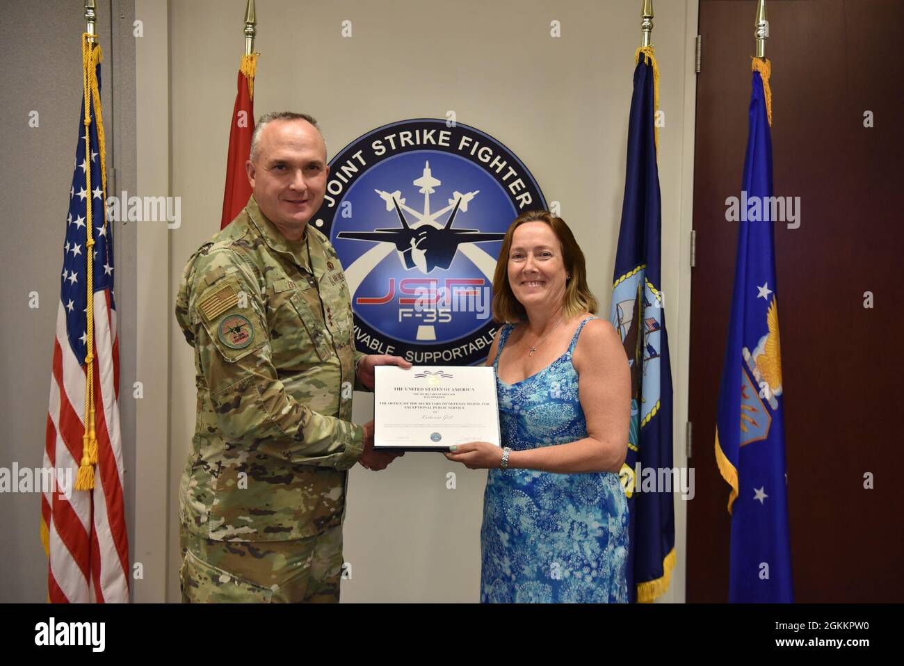 Lt. Gen. Eric Fick, F-35 Joint Program Executive Officer, presents Katherine Gill, F-35 Software Sustainment Team Lead, with the Office of the Secretary of Defense Medal for Exceptional Public Service certificate during a semi-virtual all hands ceremony at the program headquarters in Arlington, Va. The F-35 Joint Program Office is the Department of Defense's focal point for the 5th generation strike aircraft for the Navy, Air Force, Marines, and our allies. The F-35 is the premier multi-mission, 5th generation weapon system. Its ability to collect, analyze and share data is a force multiplier Stock Photo