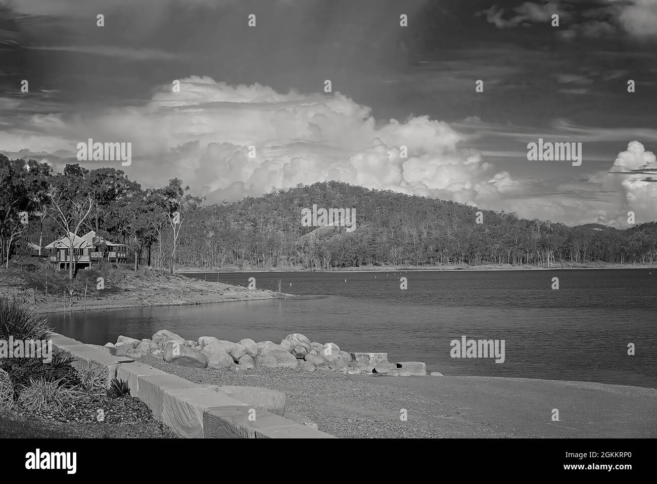 Monotone of rocks from an old jetty with shaded structures for public ...