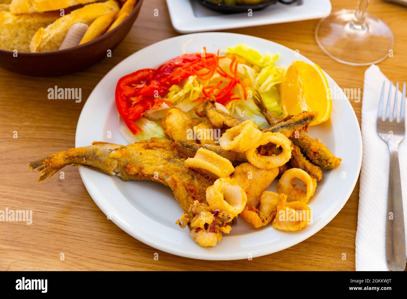 Fried seafood delicacies with fresh vegetables and lemon Stock Photo