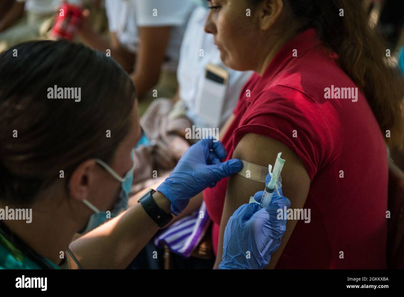 U.S. Army 1st Lt. Emily Bradley, an emergency room nurse with the Medical Element, Joint Task Force-Bravo, Soto Cano Air Base, Honduras, gives a Salvadoran woman anti-nausea medicine during a medical readiness training exercise for Resolute Sentinel 21 in El Jaguey, El Salvador, May 20, 2021. Medical members treated 341 Salvadoran patients through preventative medicine, primary care, dental, and pharmacy services during the exercise. Stock Photo
