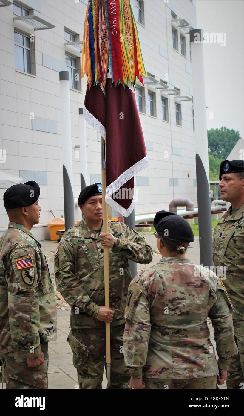 On May 20, 2021, Lt. Col. Qui Nguy, incoming commander, takes the unit colors of the 502nd Field Hospital during a change of command ceremony on the patio of the Brian D. Allgood Army Community Hospital at Humphreys.  Since the unit’s activation in July of 2019, the 'Silver Dragons' under Torres leadership have transitioned from one installation to another, building the field hospital from a combat support hospital to managing a dual personnel mission and being at the spearhead of the COVID-19 pandemic. Stock Photo