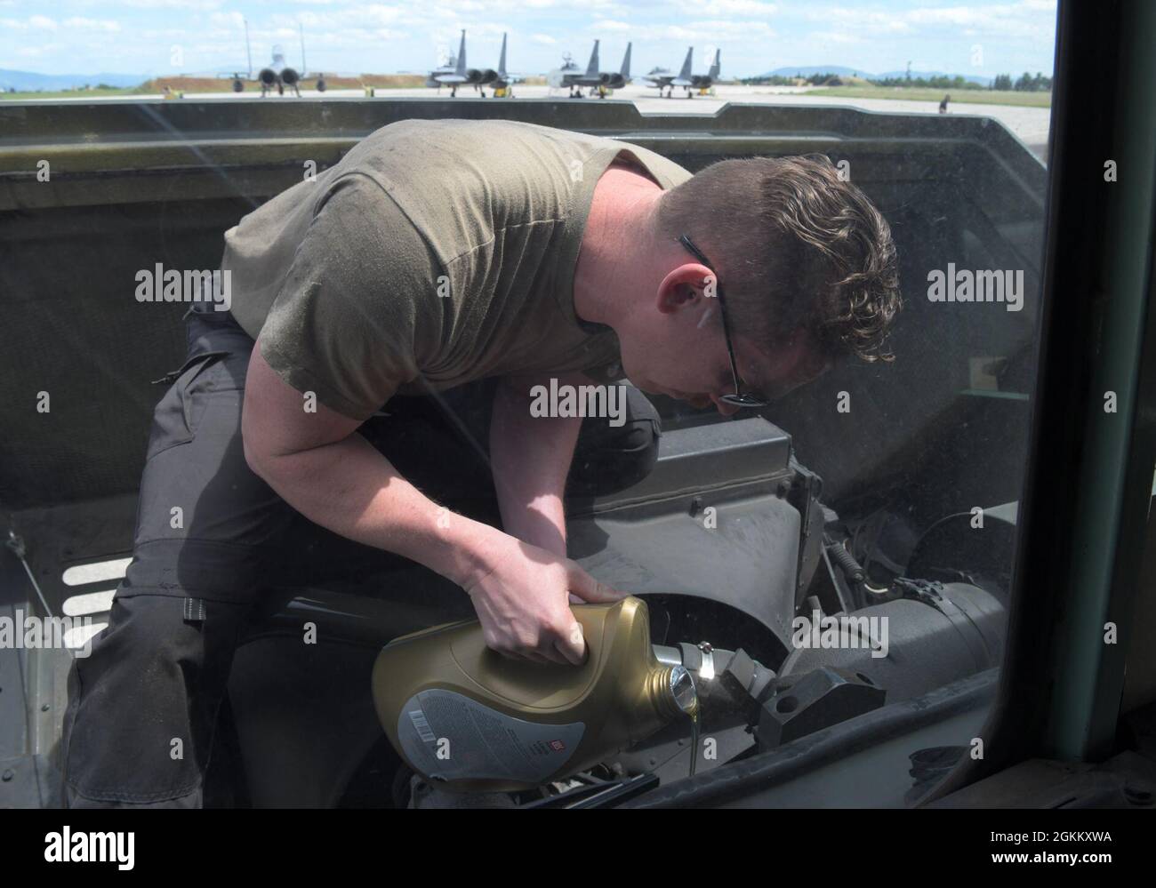 U.S. Air Force Staff Sgt. Kevin Grimm, 48th Logistics Readiness Squadron vehicle maintenance craftsman, tops off the oil on a refueling truck during exercise Astral Knight 21 at Larissa Air Base, Greece, May 20, 2021. During Astral Knight 21, the Liberty Wing sharpened its ability to deploy capable, credible forces to operate from strategic locations, which is enabled by strong regional partnerships critical for a rapid united response to adversaries around the world. Stock Photo