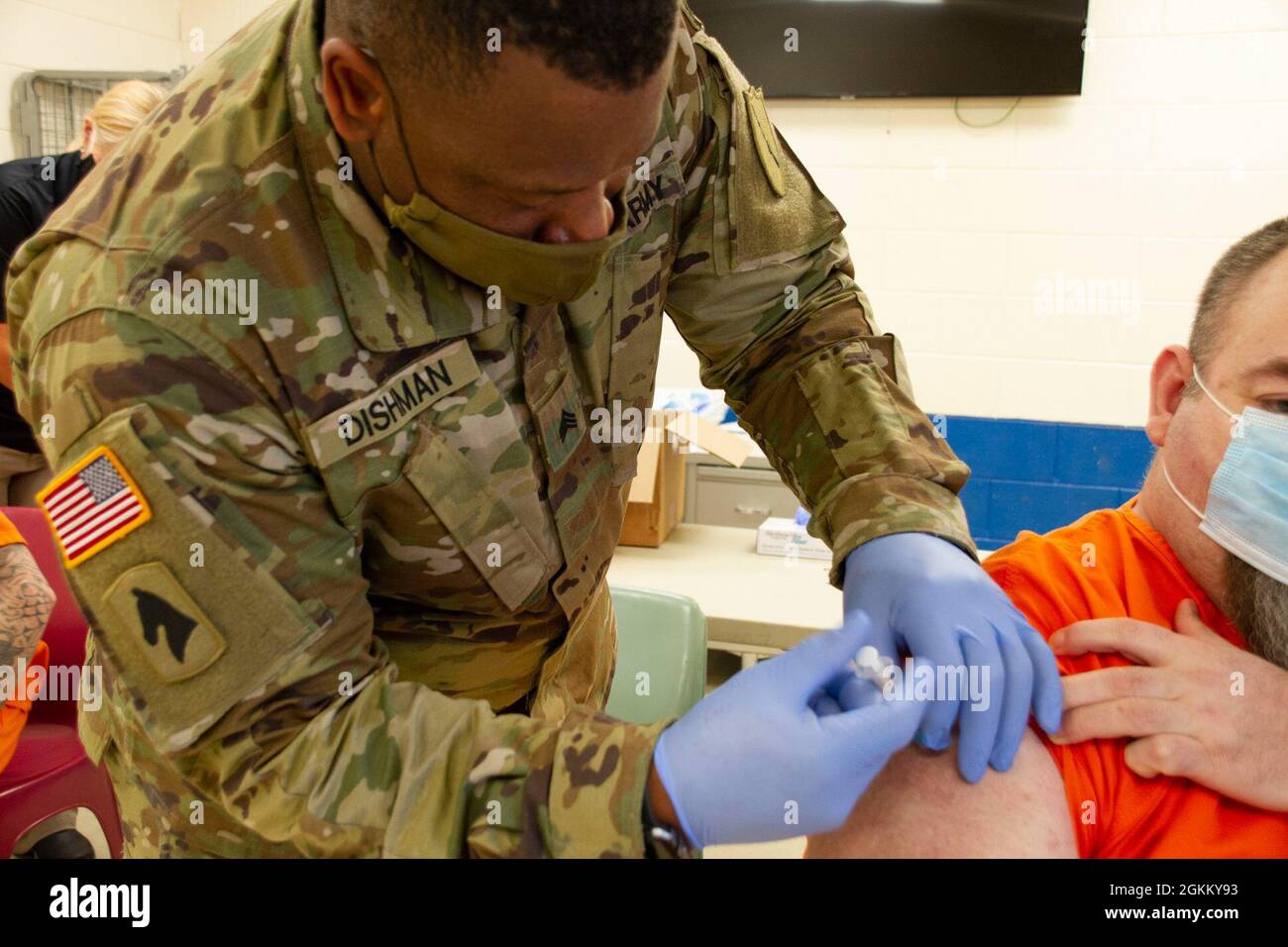 Sgt. Okoarye Dishman, a medic assigned to vaccination strike team two, Kentucky National Guard, administers a COVID-19 vaccination to a detainee at the Big Sandy Regional Detention Center, Paintsville, Ky. May 20. This comes in part to COVID-19 vaccine distribution throughout the commonwealth. Stock Photo