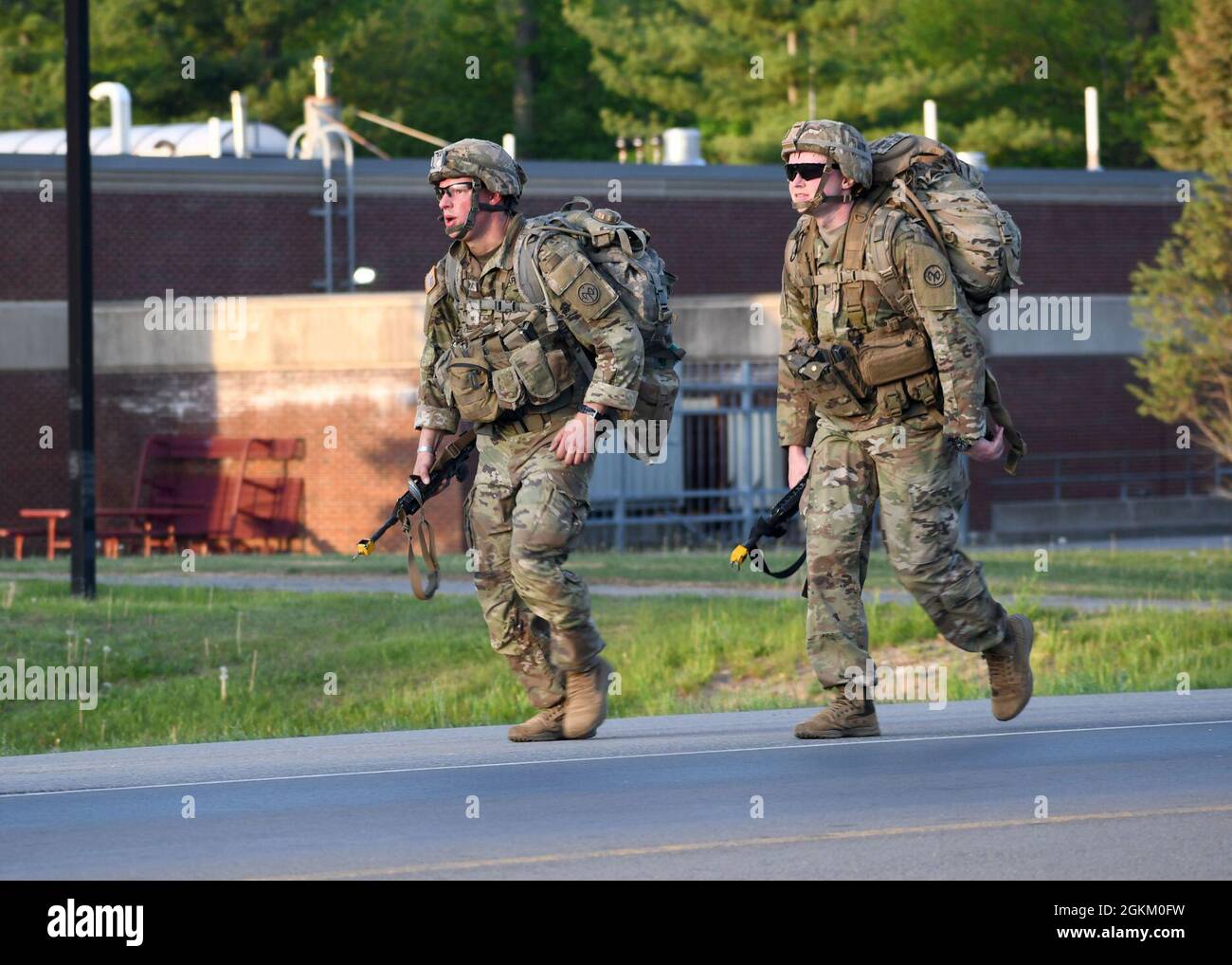 FORT DRUM, N.Y. – U.S. Army Staff Sgt. Robert Majewski, left, with 2nd Squadron, 101st Cavalry Regiment, and 1st Lt. Phillip Mullen with 1st Battalion, 69th Infantry Regiment, both infantrymen with the New York National Guard, conduct a 12-mile foot march as part of the 10th Mountain Division Expert Infantryman Badge assessment at Fort Drum, N.Y., May 21, 2021. Stock Photo