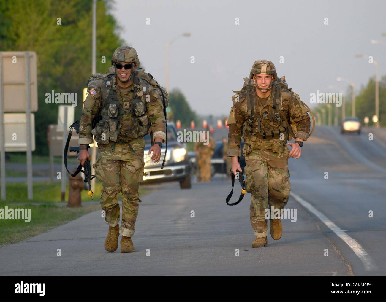 FORT DRUM, N.Y. – U.S. Army Sgt. Troy Perez, left, and Sgt. Joseph Ryan, both infantrymen with the New York National Guard’s 1st Battalion, 69th Infantry Regiment, conduct a 12-mile foot march as part of the 10th Mountain Division Expert Infantryman Badge assessment at Fort Drum, N.Y., May 21, 2021. Stock Photo