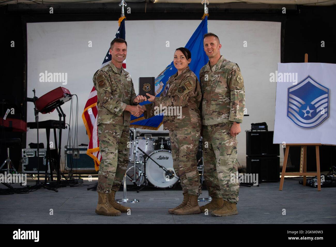 U.S. Air Force Brig. Gen. Larry R. Broadwell, 380th Air Expeditionary Wing commander (AEW), and Chief Master Sgt. Joshua J. Wiener, 380th AEW command chief, pose with Tech. Sgt. Melanie Atkins, 380th Expeditionary Security Forces Squadron,  at Al Dhafra Air Base (ADAB), United Arab Emirates, May 21, 2021. Atkins is one of 19 team ADAB technical sergeants that were selected for promoted to master sergeant this year. Stock Photo