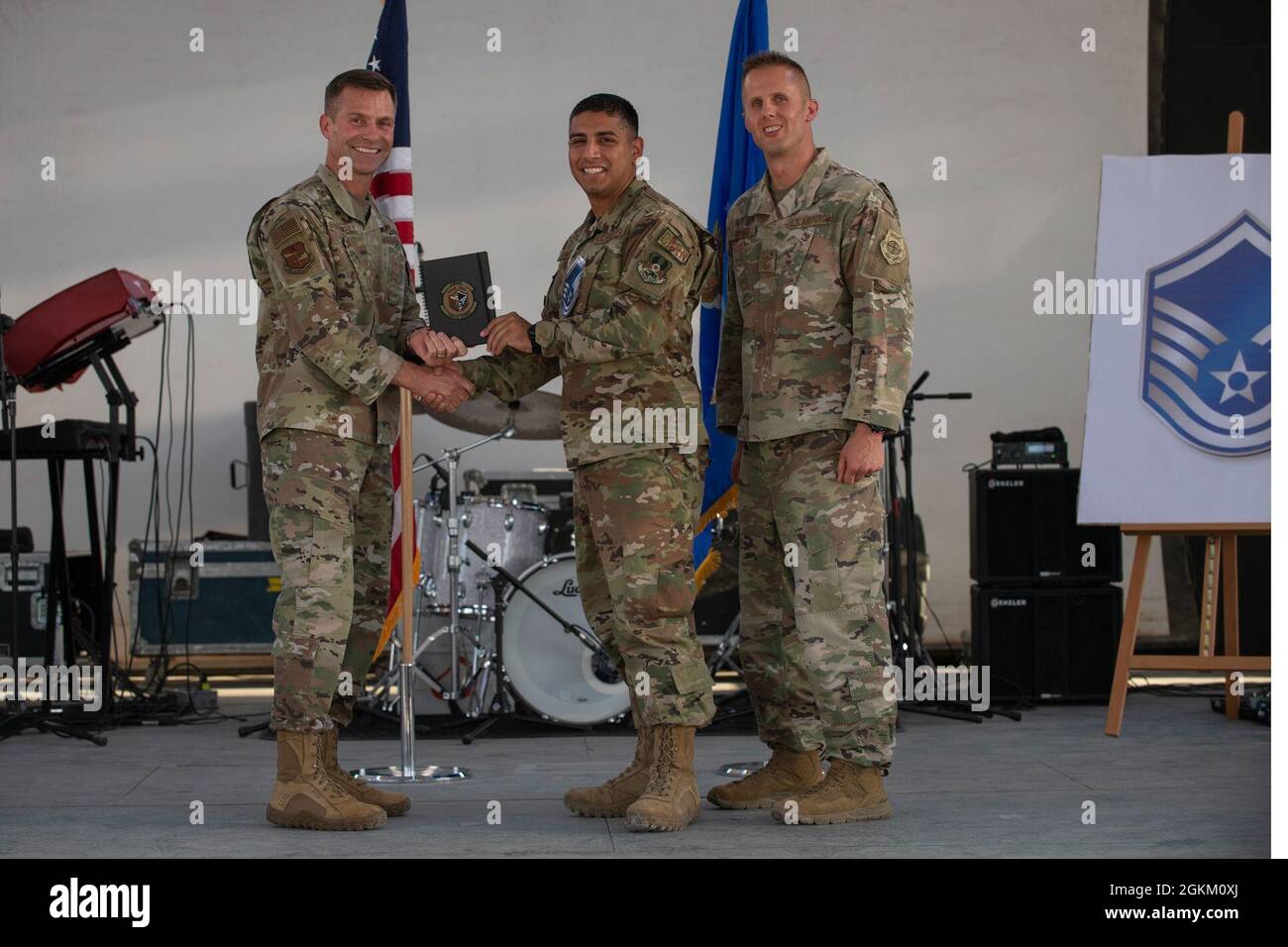 U.S. Air Force Brig. Gen. Larry R. Broadwell, 380th Air Expeditionary Wing commander (AEW), and Chief Master Sgt. Joshua J. Wiener, 380th AEW command chief, pose with Tech. Sgt. Carlos Gomez, 380th Expeditionary Civil Engineer Squadron, at Al Dhafra Air Base (ADAB), United Arab Emirates, May 21, 2021. Gomez is one of 19 team ADAB technical sergeants that were selected for promoted to master sergeant this year. Stock Photo
