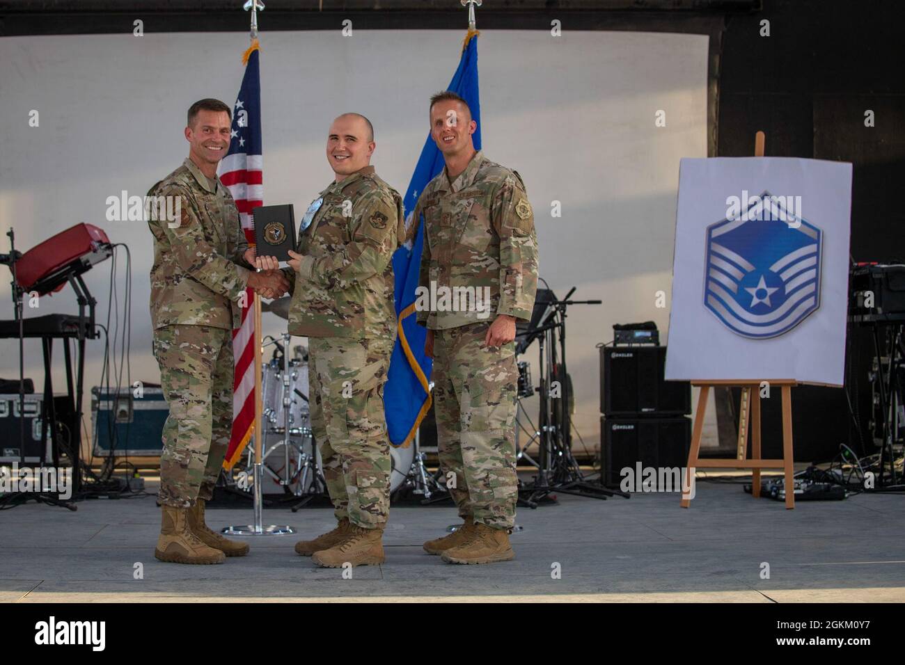 U.S. Air Force Brig. Gen. Larry R. Broadwell, 380th Air Expeditionary Wing commander (AEW), and Chief Master Sgt. Joshua J. Wiener, 380th AEW command chief, pose with Tech. Sgt. Christopher Yetter, 380th Expeditionary Force Support Squadron, at Al Dhafra Air Base (ADAB), United Arab Emirates, May 21, 2021. Yetter is one of 19 team ADAB technical sergeants that were selected for promoted to master sergeant this year. Stock Photo