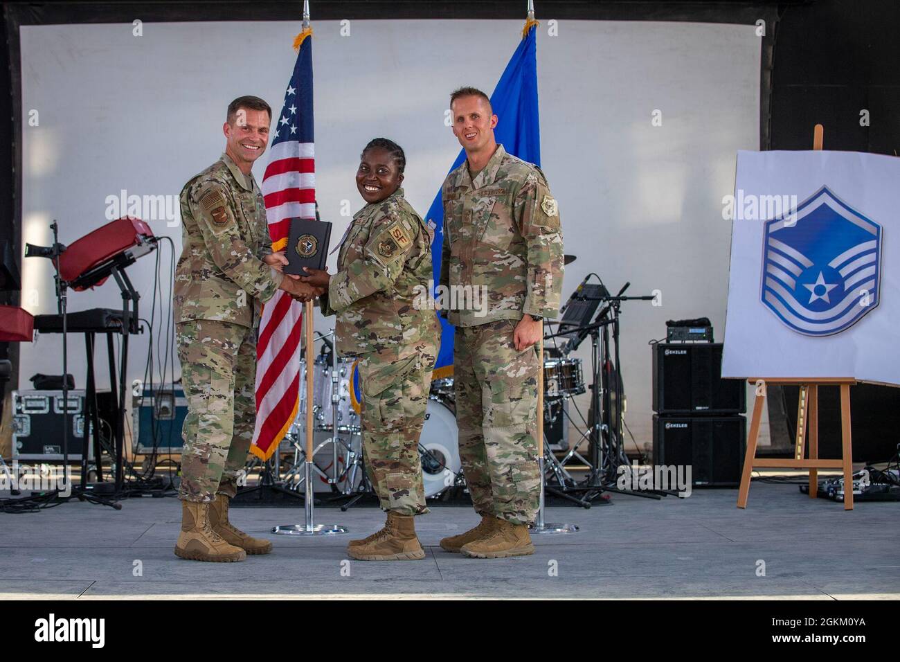 U.S. Air Force Brig. Gen. Larry R. Broadwell, 380th Air Expeditionary Wing commander (AEW), and Chief Master Sgt. Joshua J. Wiener, 380th AEW command chief, pose with Tech. Sgt. Tianna Harris, 380th Expeditionary Security Forces Squadron, at Al Dhafra Air Base (ADAB), United Arab Emirates, May 21, 2021. Harris is one of 19 team ADAB technical sergeants that were selected for promoted to master sergeant this year. Stock Photo