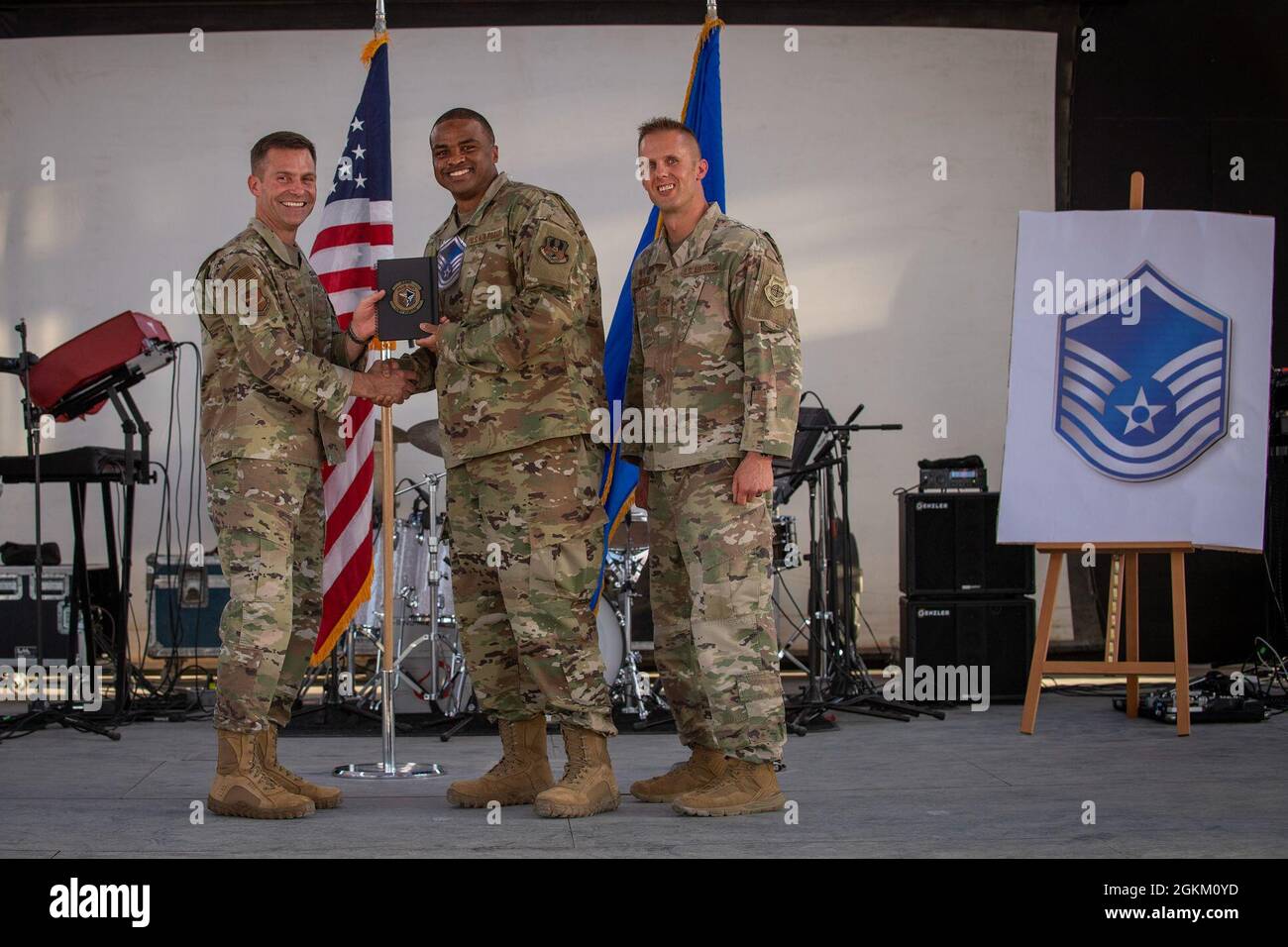 U.S. Air Force Brig. Gen. Larry R. Broadwell, 380th Air Expeditionary Wing commander (AEW), and Chief Master Sgt. Joshua J. Wiener, 380th AEW command chief, pose with Tech. Sgt. Lewis Hampton, 380th Expeditionary Contracting Squadron, at Al Dhafra Air Base (ADAB), United Arab Emirates, May 21, 2021. Hampton is one of 19 team ADAB technical sergeants that were selected for promoted to master sergeant this year. Stock Photo