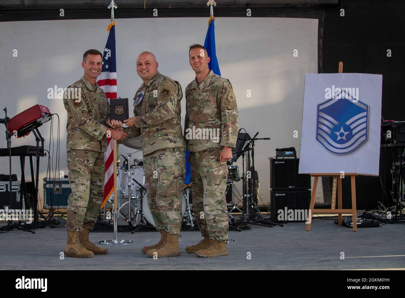 U.S. Air Force Brig. Gen. Larry R. Broadwell, 380th Air Expeditionary Wing commander (AEW), and Chief Master Sgt. Joshua J. Wiener, 380th AEW command chief, pose with Tech. Sgt. Brandon Peterson, 380th Expeditionary Maintenance Group, at Al Dhafra Air Base (ADAB), United Arab Emirates, May 21, 2021. Peterson is one of 19 team ADAB technical sergeants that were selected for promoted to master sergeant this year. Stock Photo