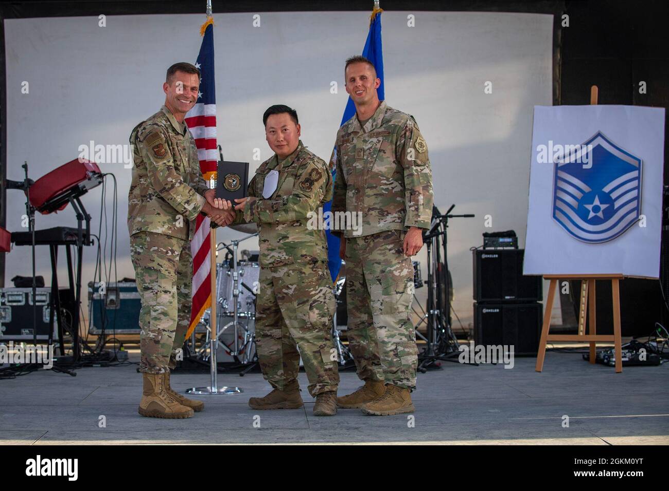 U.S. Air Force Brig. Gen. Larry R. Broadwell, 380th Air Expeditionary Wing commander (AEW), and Chief Master Sgt. Joshua J. Wiener, 380th AEW command chief, pose with Tech. Sgt. Nqoua Yang, 380th Expeditionary Wing Staff Agencies, at Al Dhafra Air Base (ADAB), United Arab Emirates, May 21, 2021. Yang is one of 19 team ADAB technical sergeants that were selected for promoted to master sergeant this year. Stock Photo