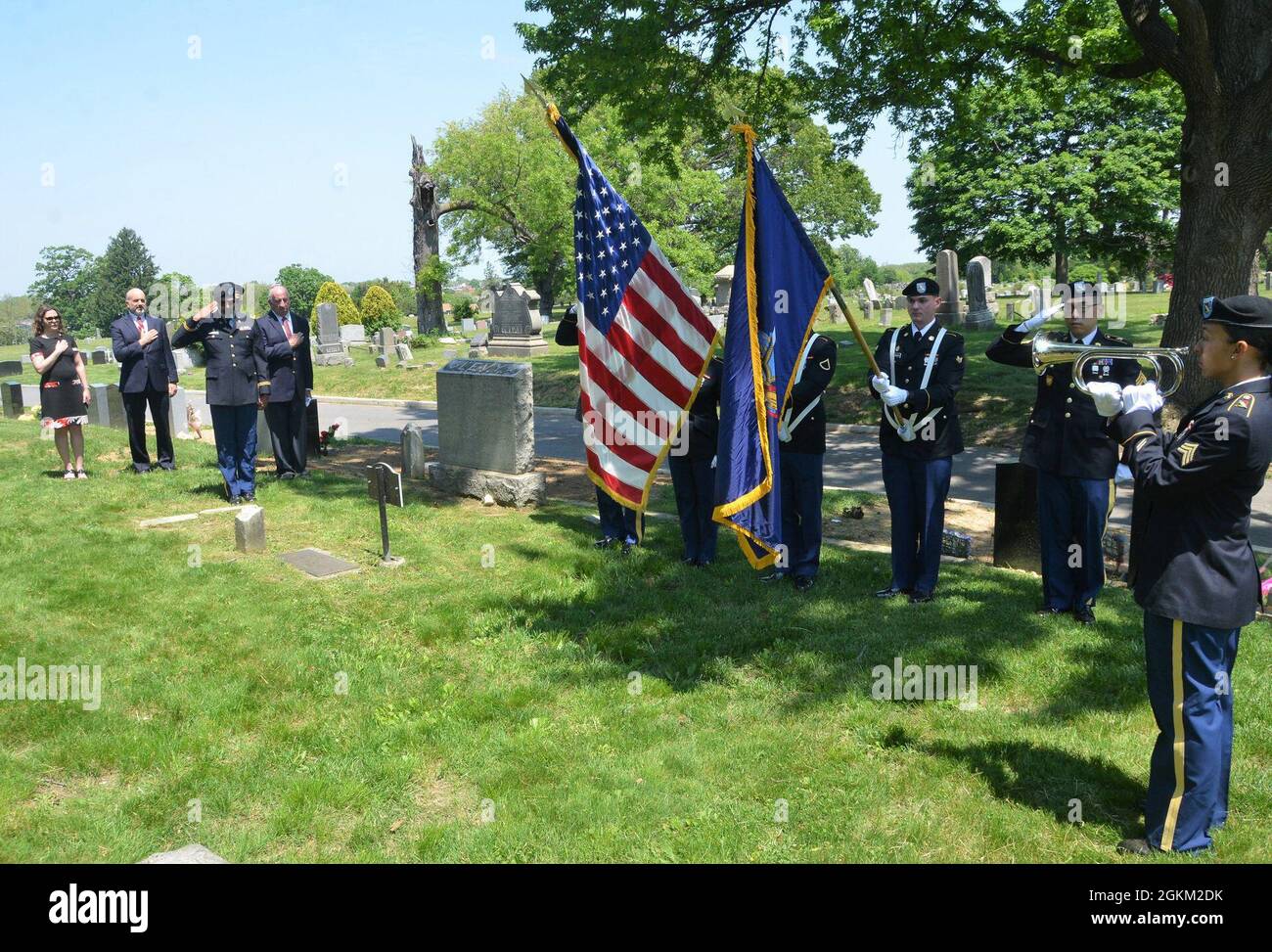 New York Army National Guard Sgt. Letty Luiz, far right, plays taps alongside a color guard of the 107th Military Police Company to render honors during a remembrance ceremony of Union Sgt. Benjamin Levy, the first Jewish American to receive the Medal of Honor, at his burial site at Cypress Hills Cemetery in Brooklyn, N.Y., May 21, 2021. Levy was a New York Soldier who received the Medal of Honor for his actions to save his regimental colors and rally his unit, the 1st New York Volunteer Infantry Regiment, during the Battle of Glendale in June 1862. Stock Photo