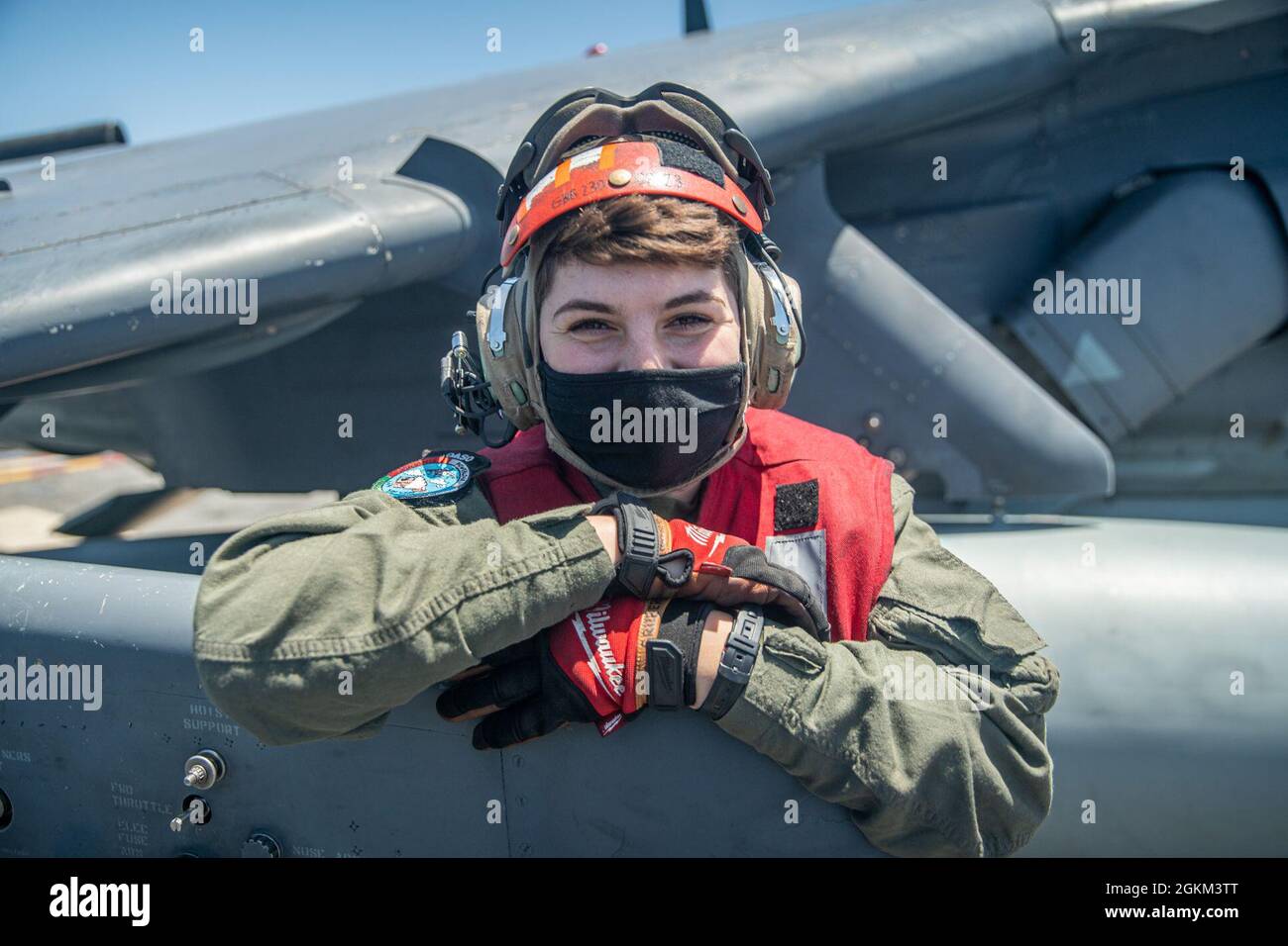 PACIFIC OCEAN (May 21, 2021) U.S. Marine Corps Cpl. Gigi Gruber, an ordnance quality assurance safety observer with Marine Attack Squadron (VMA) 214, 11th Marine Expeditionary Unit (MEU), poses for a photo with an AV-8B Harrier on the flight deck of amphibious assault ship USS Essex (LHD 2), May 21. Aside from equipping aircraft with munitions, Gruber’s responsibilities include inspecting aircraft and ordnance prior to takeoff to ensure that nothing will compromise the safety of the aircraft or pilot. Marines and Sailors of the 11th MEU and Essex Amphibious Ready Group (ARG) are underway condu Stock Photo