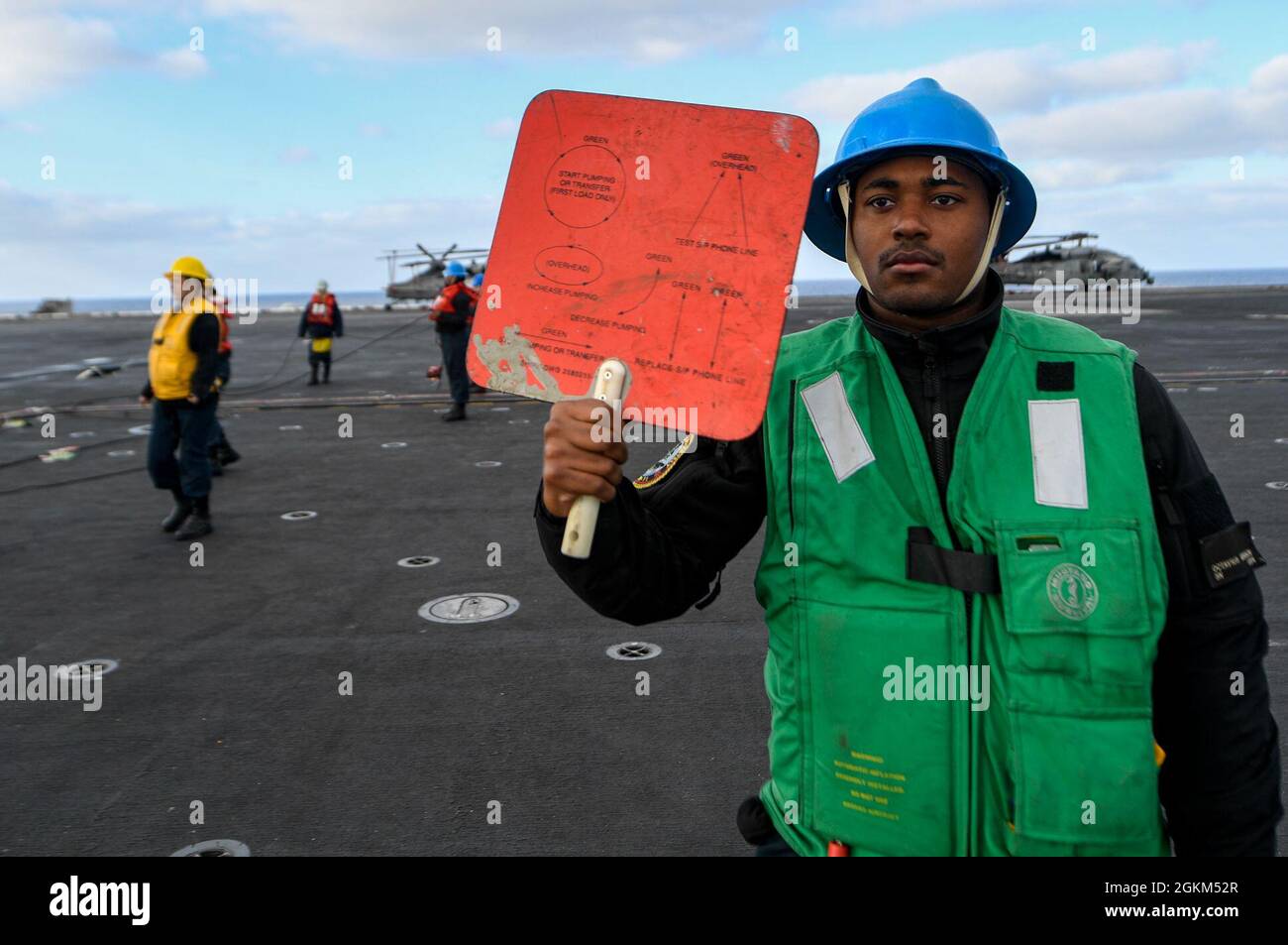 PACIFIC OCEAN (May 22, 2021) – U.S. Navy Seaman Minson Octavius, from Atlanta, holds a signal paddle aboard the aircraft carrier USS Theodore Roosevelt (CVN 71) during a replenishment-at-sea, May 22, 2021. The Theodore Roosevelt Carrier Strike Group is on a scheduled deployment conducting routine operations in U.S. 3rd Fleet. Stock Photo