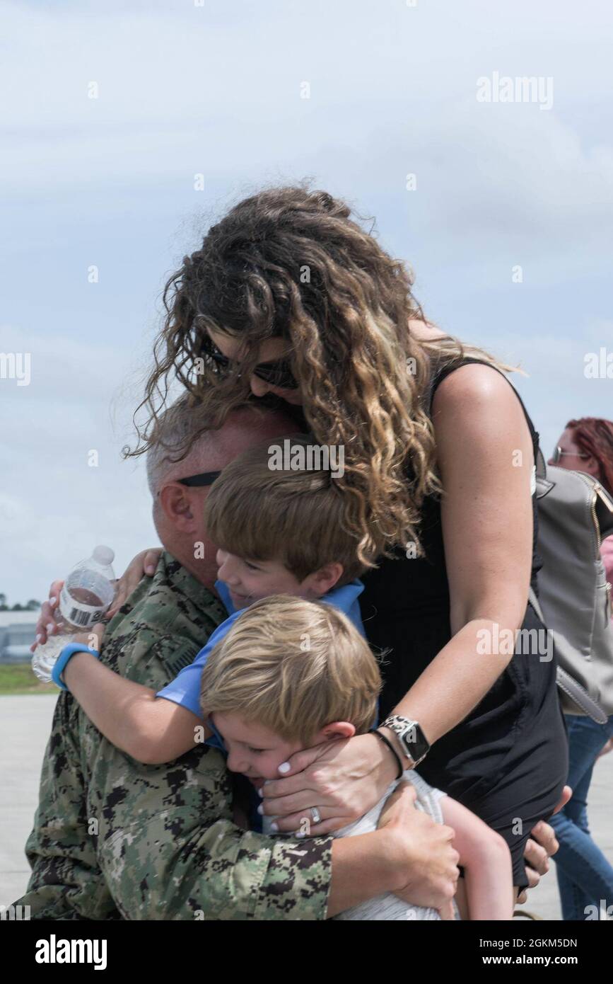 Members from Coast Guard Port Security Unit 308 reunite with their family members and loved ones at Stennis International Airport in Kiln, Miss., after a nine-month deployment to Guantanamo Bay, Cuba May 22, 2021. Port Security Units deploy with the Navy Expeditionary Combat Commands as part of the Maritime Expeditionary Security Force, in support of a geographic combatant command, joint task force commander, or a Coast Guard operational or incident commander. Stock Photo