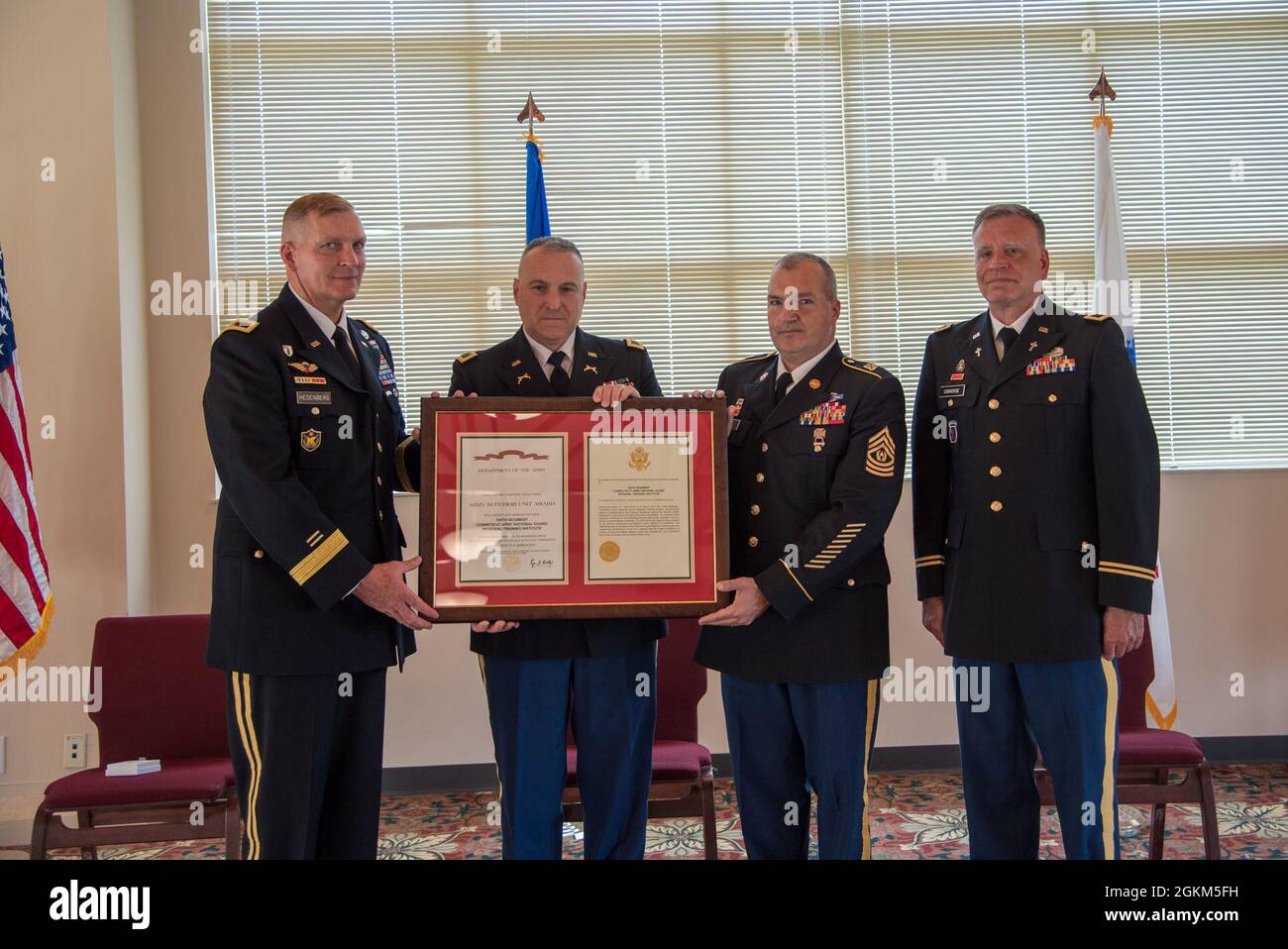 Brigadier Gen. Ralph Hedenberg (left), director of the Connecticut National Guard joint staff, presents the Army Superior Unit Award to Col. L.J. Fusaro and Command Sgt. Maj. Paul Vicinus, commander and senior enlisted advisor, respectively, for the 169th Regiment (Regional Training Institute) during a ceremony at Camp Nett in Niantic, Conn. May 22, 2021. The regiment earned the award between April 1, 2016 and March 31, 2017 by achieving the highest rating possible and no negative remarks on any of the 28 specific accreditation-based functional areas of its triennial accreditation, developing Stock Photo