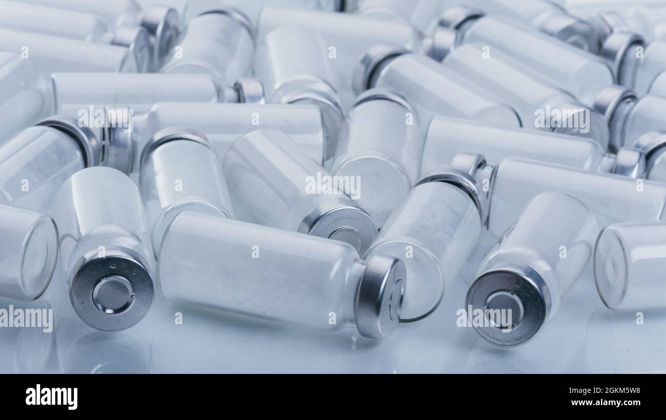 Glass medical ampoule vial for injection. Medicine is dry white drug penicillin powder or liquid with of aqueous solution in ampulla. Close up. Stock Photo