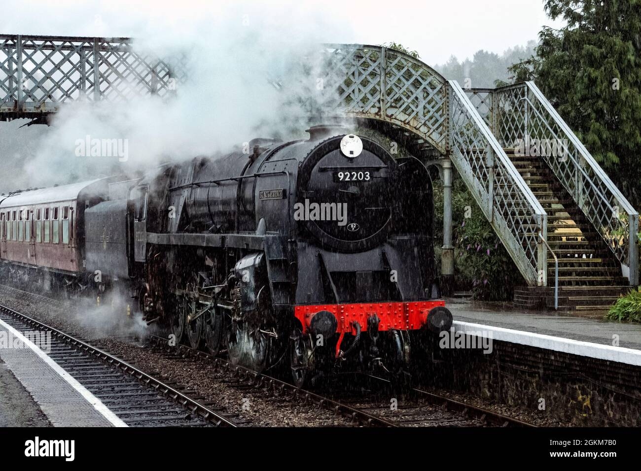 Black Prince 92203 BR 9F steam locomotive pulling a passenger train into Weybourne Station on the North Norfolk Railway Stock Photo