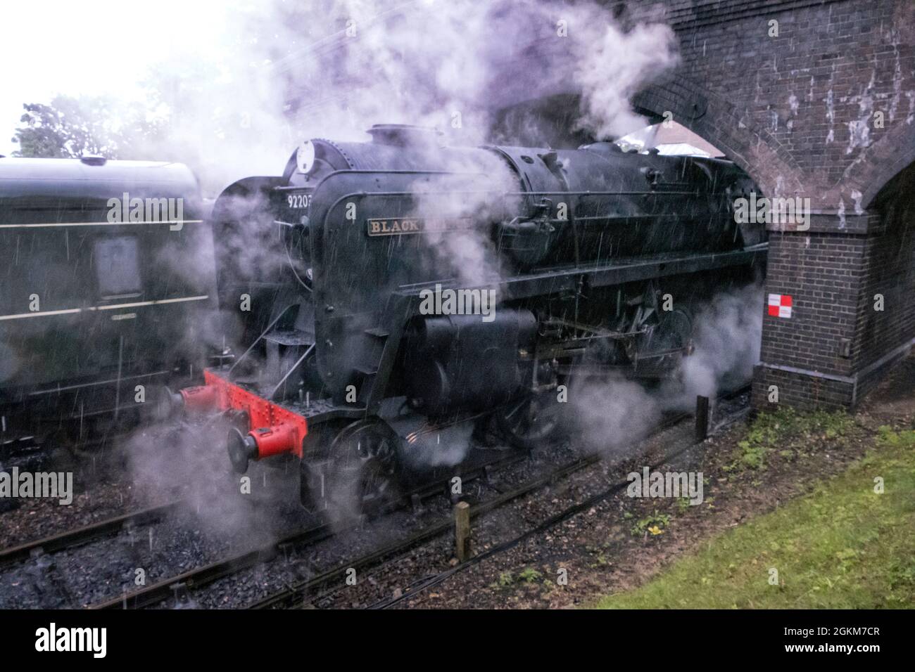 Black Prince 92203 BR 9F steam locomotive pulling a passenger train into Weybourne Station on the North Norfolk Railway Stock Photo