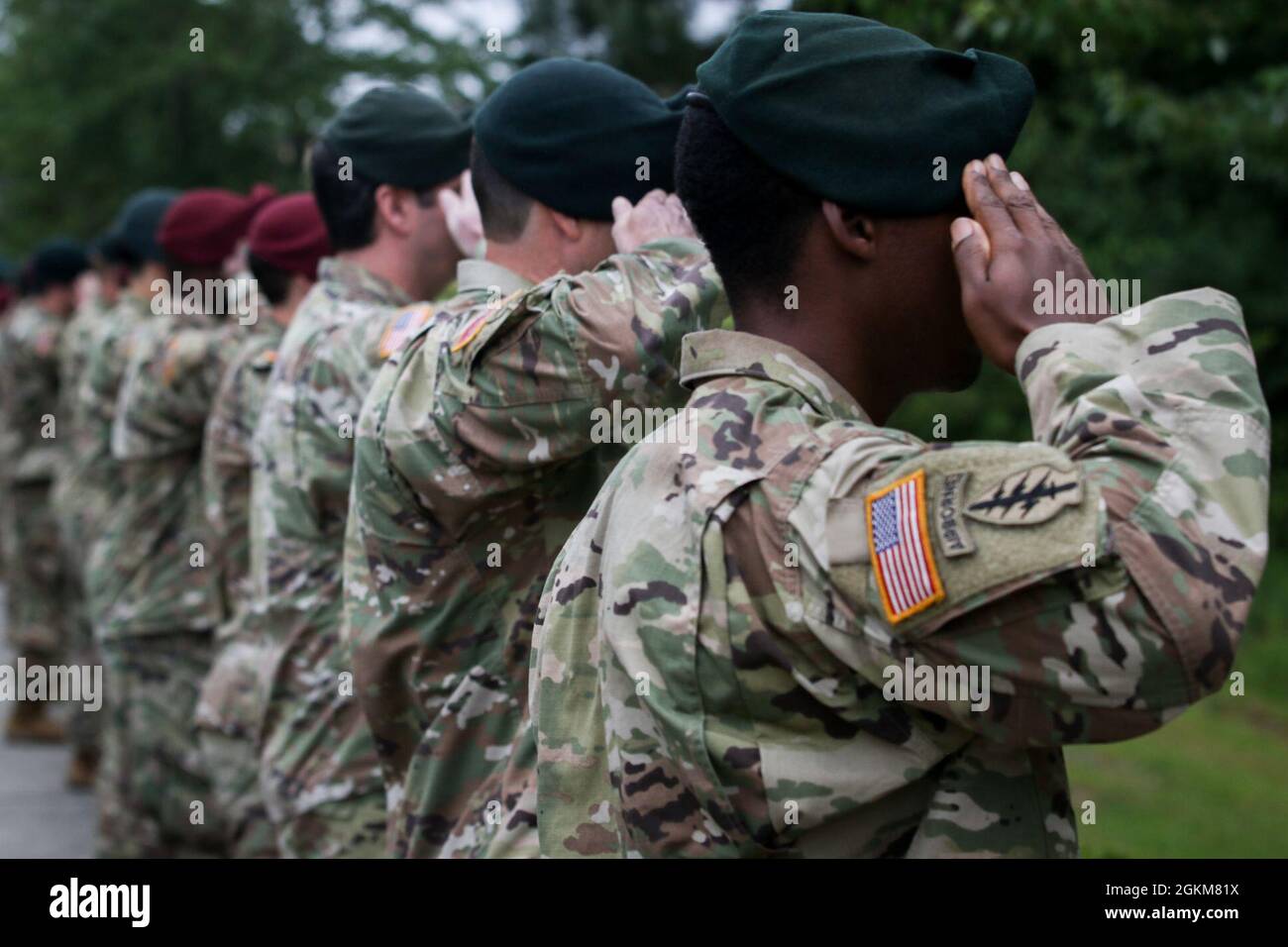 Green Berets and Soldiers assigned to 3rd Special Forces Group (Airborne) salute fallen Soldiers during the 3rd SFG (A) memorial walk ceremony at Fort Bragg, NC, May 25, 2021. Gold star family members, friends and fellow Soldiers gathered today in remembrance of Soldiers who have died while deployed and honored their memory by placing a single rose on top of their memorial stone. Stock Photo