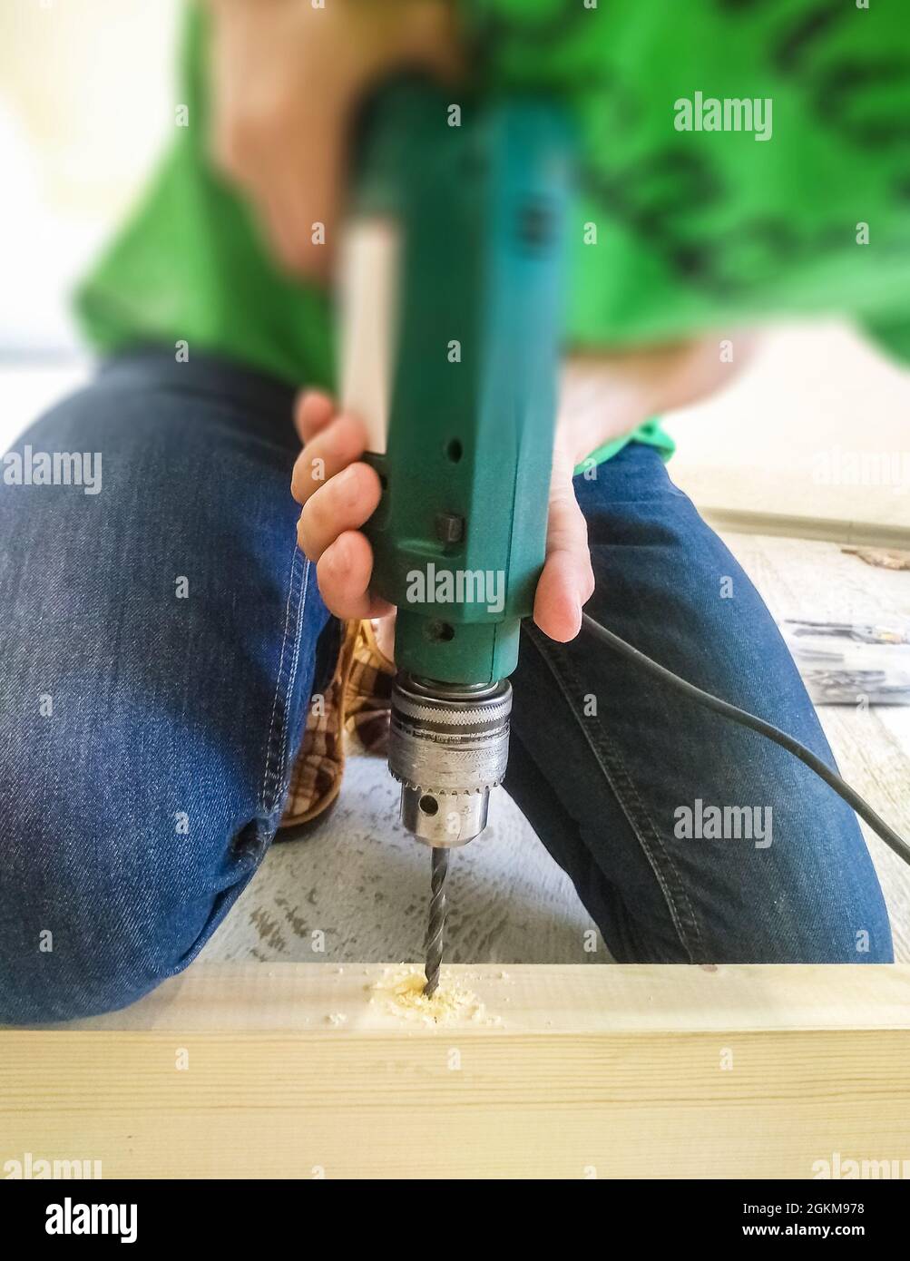 Repairman during maintenance work holding a drill Stock Photo