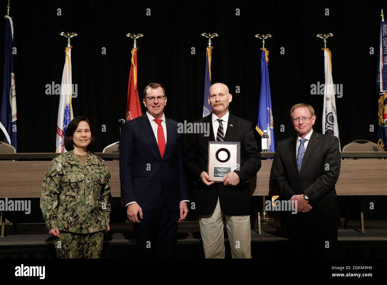 Michael Dovey, center right, principal deputy director for Naval Information Warfare Center (NIWC) Atlantic’s Cybersecurity Service Provider (CSSP) team, accepts a 2021 Department of the Navy (DON) Information Technology (IT) Excellence Award May 24 during the DON IT Conference, East Coast, at the Hilton Norfolk The Main, in Norfolk, VA. Dovey, who also serves as the deputy for defense, Defense Health Agency (DHA) Cyber Operations Center, was named the DON Cyberspace/Information Technology Person of the Year for his work leading cybersecurity professionals in countering existing and emerging t Stock Photo