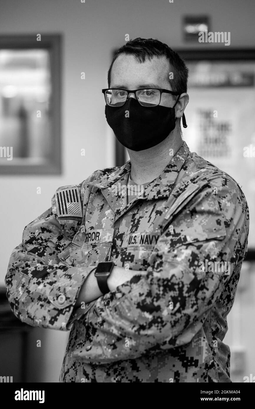 U.S. Navy Petty Officer 3rd Class Ryker Borror, a steel worker assigned to Amphibious Construction Battalion 1, poses for a photo at the Tulsa Community Vaccination Center (CVC) in Tulsa, Oklahoma, May 25, 2021. Borror is both an entrance and exit greeter at the Tulsa CVC. U.S. Northern Command, through U.S. Army North, remains committed to providing continued, flexible Department of Defense support to the Federal Emergency Management Agency as part of the whole-of-government response to COVID-19. Stock Photo