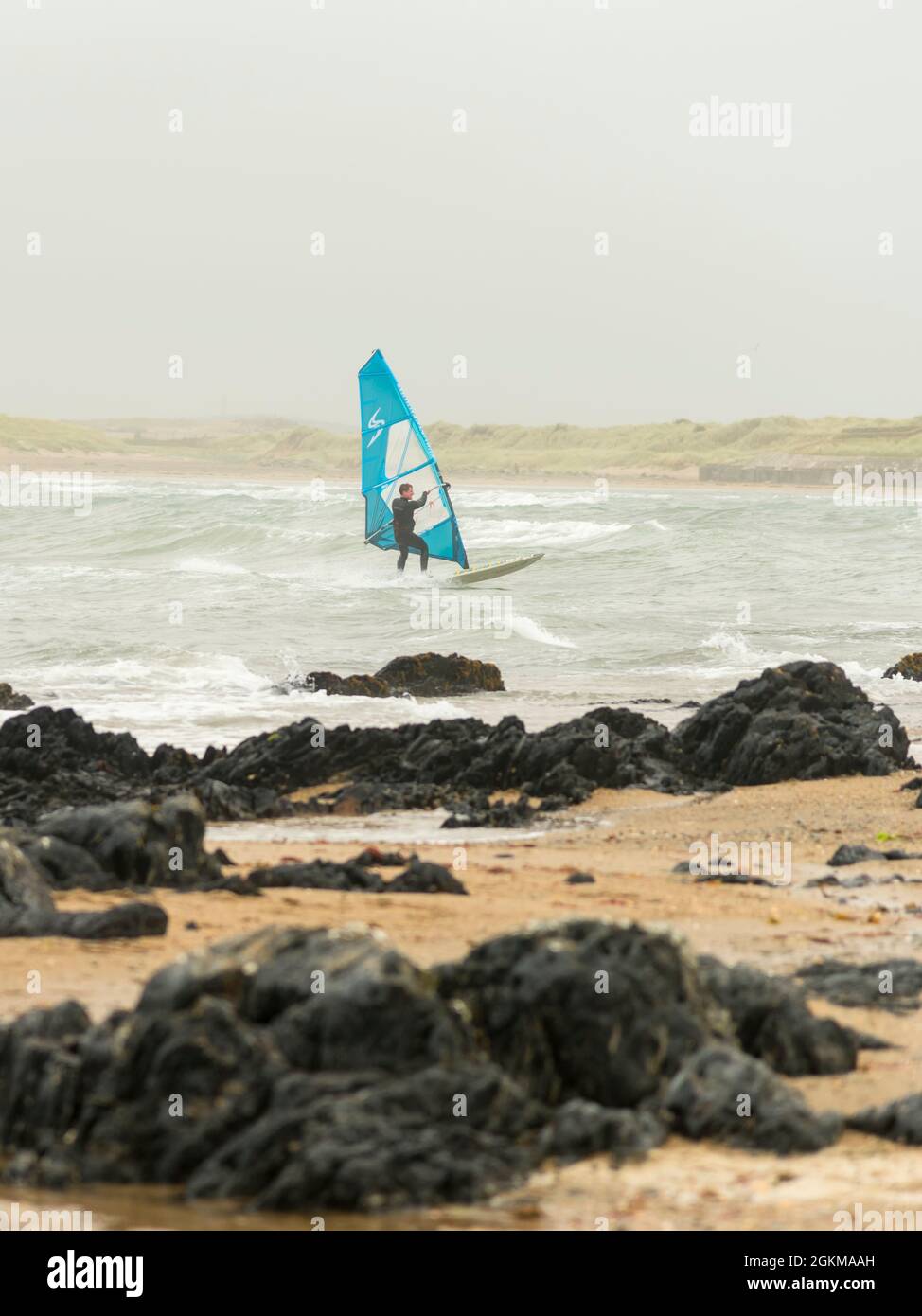 Windsurfing off the beach in Anglesey North Wales England UK Stock