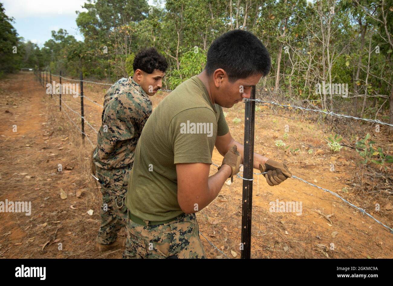 U.S. Marine Corps Lance Cpl. David Sotelo, right, and Cpl. David Padilla, left, both combat engineers with Combat Logistics Battalion 7, Marine Rotational Force – Darwin, build a barbed wire fence during exercise Crocodile Response at Point Fawcett, NT, Australia, May 25, 2021. Exercise Crocodile Response tested the ability of MRF-D and the Australian Defence Force to provide disaster relief in the Indo-Pacific region. The rotational deployment of U.S. Marines affords a combined training opportunity with Australia and improves cooperation and integration between the two country’s forces. Stock Photo