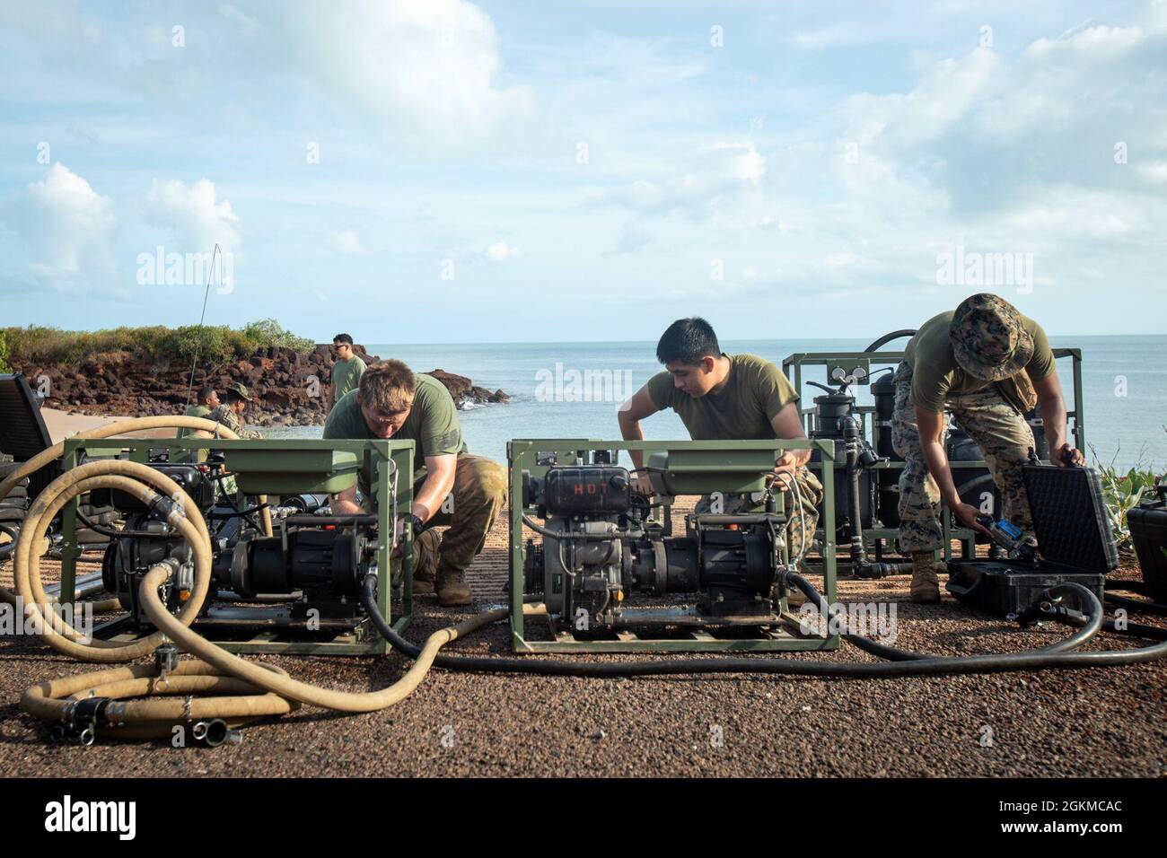 U.S. Marine Corps Lance Cpl. Jose MartinezLopez, right, and Lance Cpl. Jerry GarciaVillegas, center, both water support technicians with Combat Logistics Battalion 7, Marine Rotational Force – Darwin, and Australian Army Craftsman Benjamin Flavell, left, set-up a water purification point during exercise Crocodile Response at Point Fawcett, NT, Australia, May 25, 2021. Using the Marine Corps’ LWPS, Marines and Australian Army soldiers exercised their ability to purify water during a simulated natural disaster. Exercise Crocodile Response tested the ability of MRF-D and the Australian Defence Fo Stock Photo