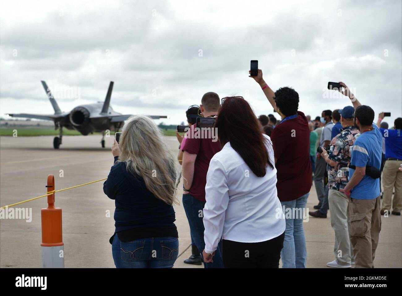 Members of the Oklahoma City Air Logistics Complex Heavy Maintenance Center take pictures as an Air Force F-35 Lightning II Demonstration Team aircraft taxis to the runway at Tinker Air Force Base, Oklahoma, May 25, 2021. The men and women of the HMC support all models of the F-35, including the Air Force, Navy and Marine variants, as well as those of partner nations. Stock Photo