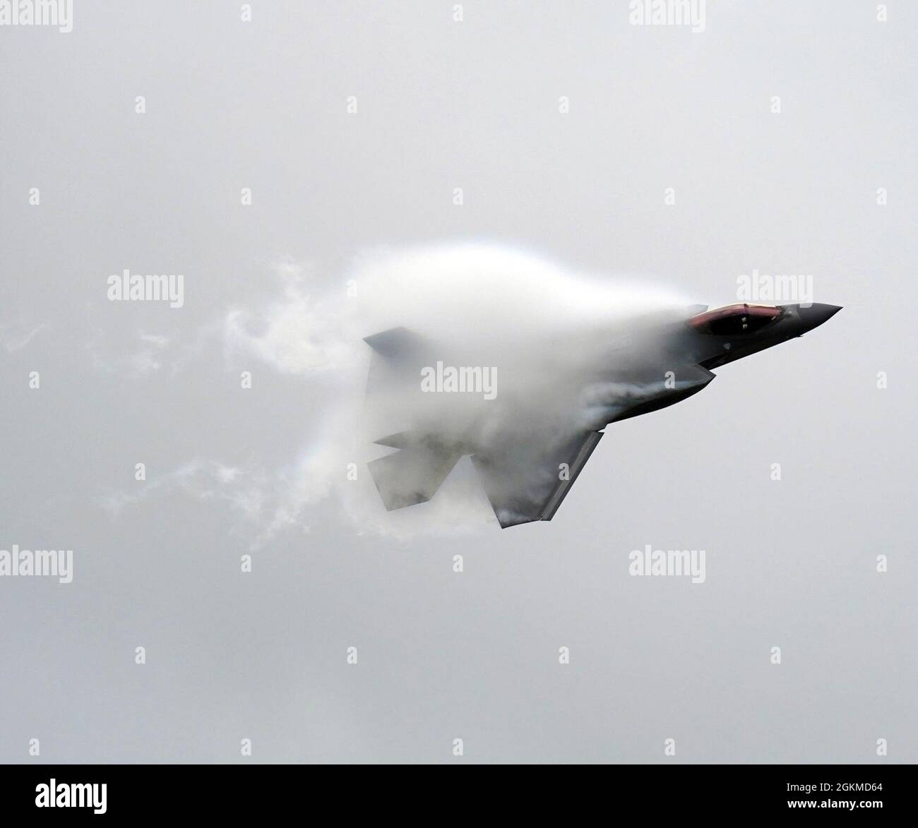 An F-35A Lightning II aircraft assigned to the Air Force’s F-35 Demo Team creates a vapor cone as it performs a demonstration flight at Tinker Air Force Base, Oklahoma, May 25, 2021. Vapor cones are visible clouds of condensed water created by aircraft flying through moist air at high speeds. Stock Photo