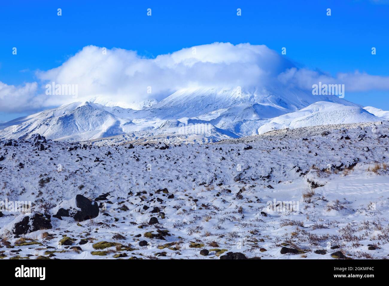 View of Mount Ngauruhoe, New Zealand, from nearby Mount Ruapehu. Both mountains are covered in snow Stock Photo