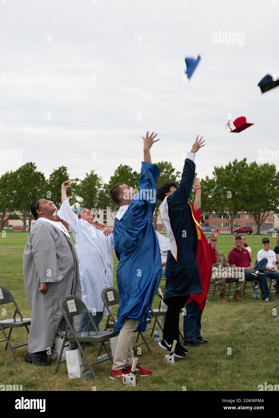 A group of Team Kirtland high school graduates toss their caps during a