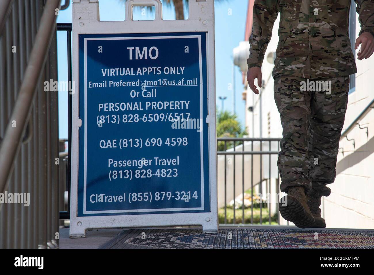 A U.S. Air Force Airman walks past a sign at the 6th Logistics Readiness Squadron Traffic Management Office entrance at MacDill Air Force Base, Florida, May 26, 2021. Any military member who is retiring, separating or changing duty stations will work with TMO, specifically personal property and passenger travel, to get their personal belongings shipped to their next home. Stock Photo