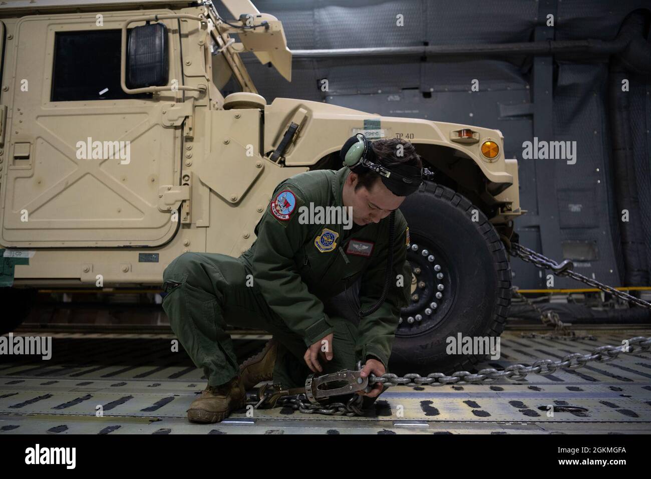 U.S. Air Force Staff Sgt. Clifford Lyter, 22nd Airlift Squadron loadmaster, checks a chain lock on a C-5M Super Galaxy May 26, 2021 at Joint Base Cape Cod, Massachusetts. A total of 10 Humvees were loaded and 23 soldiers were flown to John Glenn International airport in Columbus, Ohio. Stock Photo