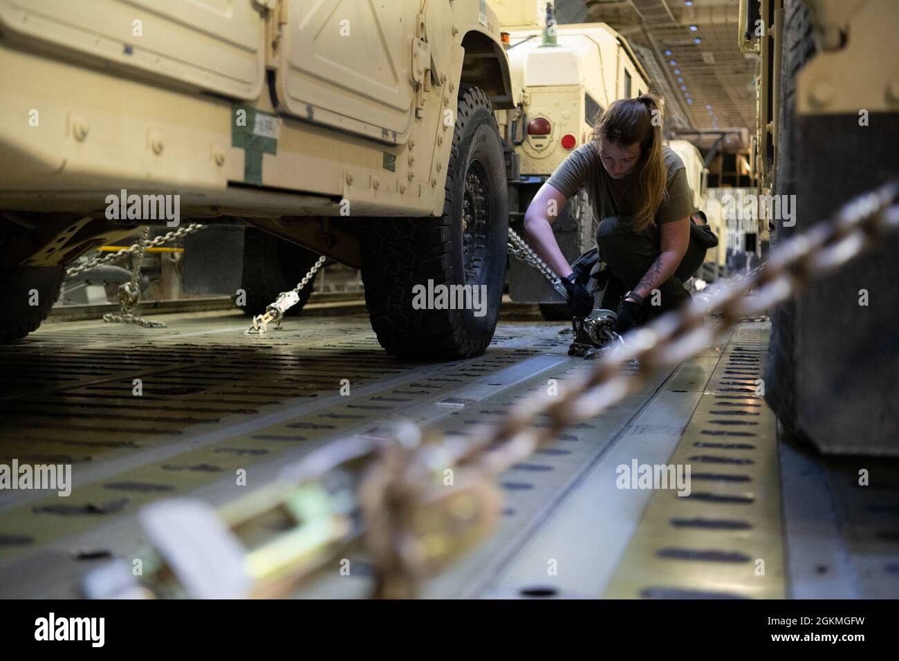 Airman 1st Class Molly Connors, 22nd Airlift Squadron loadmaster, secures a Humvee on a C-5M Super Galaxy May 26, 2021 at Joint Base Cape Cod, Massachusetts. A total of 10 Humvees and 23 soldiers were loaded onto the C-5 and flown to John Glenn Columbus International Airport, Ohio, as part of a Major Command Service Tail Trainer exercise. Stock Photo