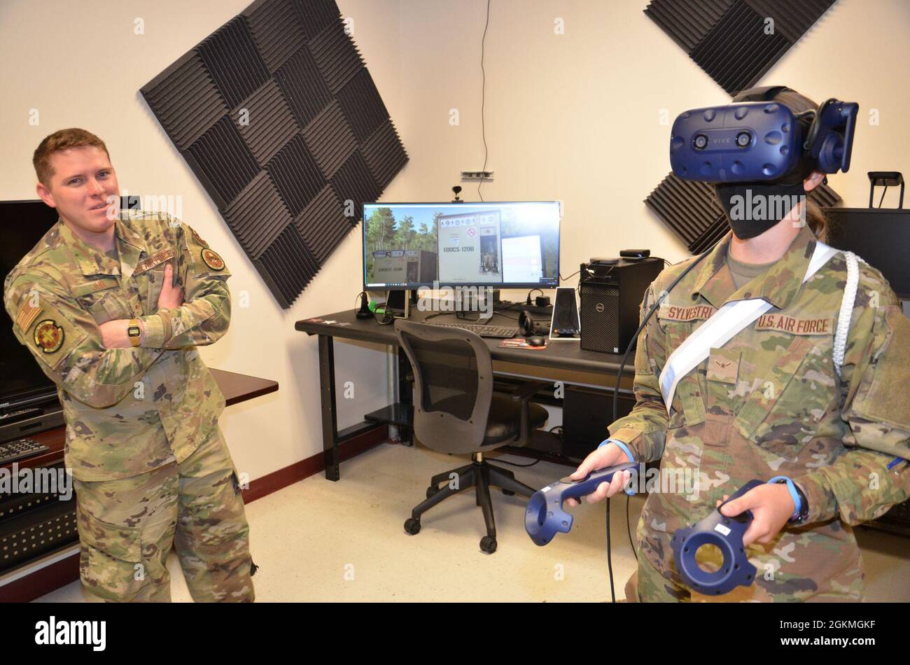 Air Force Staff Sgt. Austin Jur, a METC Biomedical Equipment Technician  (BMET) program instructor, watches as Airman Lisa Sylvestri, a METC  Radiologic Technologist student, tries out a virtual reality device  designed for