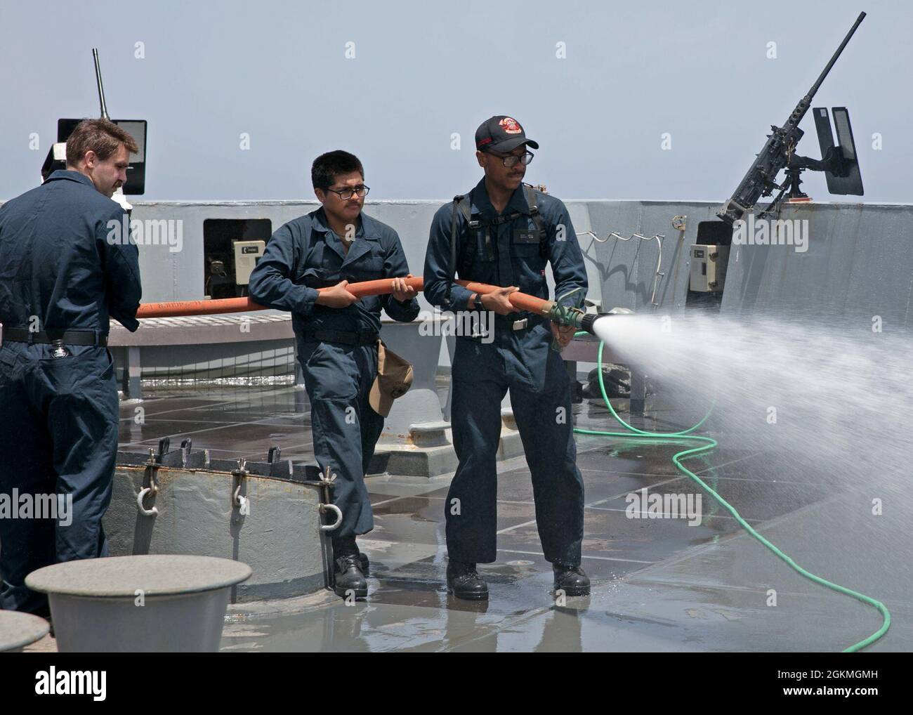 210526-N-OI940-1020   ATLANTIC OCEAN (May 26, 2021) Sailors assigned to the amphibious transport dock ship USS San Antonio (LPD 17), wash the deck with a fire hose on the ship's fo'c's'le, May 26, 2021. San Antonio is operating in the Atlantic Ocean with Amphibious Squadron 4 and the 24th Marine Expeditionary Unit (24th MEU) as part of the Iwo Jima Amphibious Ready Group. Stock Photo