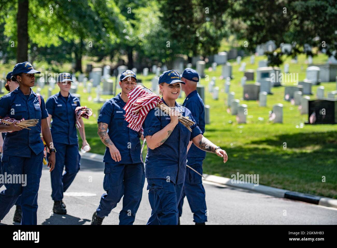 Coast guardsmen assist in placing over 265,000 U.S. flags at every gravesite, columbarium court column, and niche wall column as part of Flags-In at Arlington National Cemetery, Arlington, Virginia, May 27, 2021.    For more than 50 years, soldiers from The Old Guard have honored our nation’s fallen military heroes by placing U.S. flags at the gravesites of service members buried at both Arlington National Cemetery and the U.S. Soldiers’ and Airmen’s Home National Cemetery just prior to the Memorial Day weekend. For the first time in 20 years, members from the U.S. Marine Corps, the U.S. Navy, Stock Photo