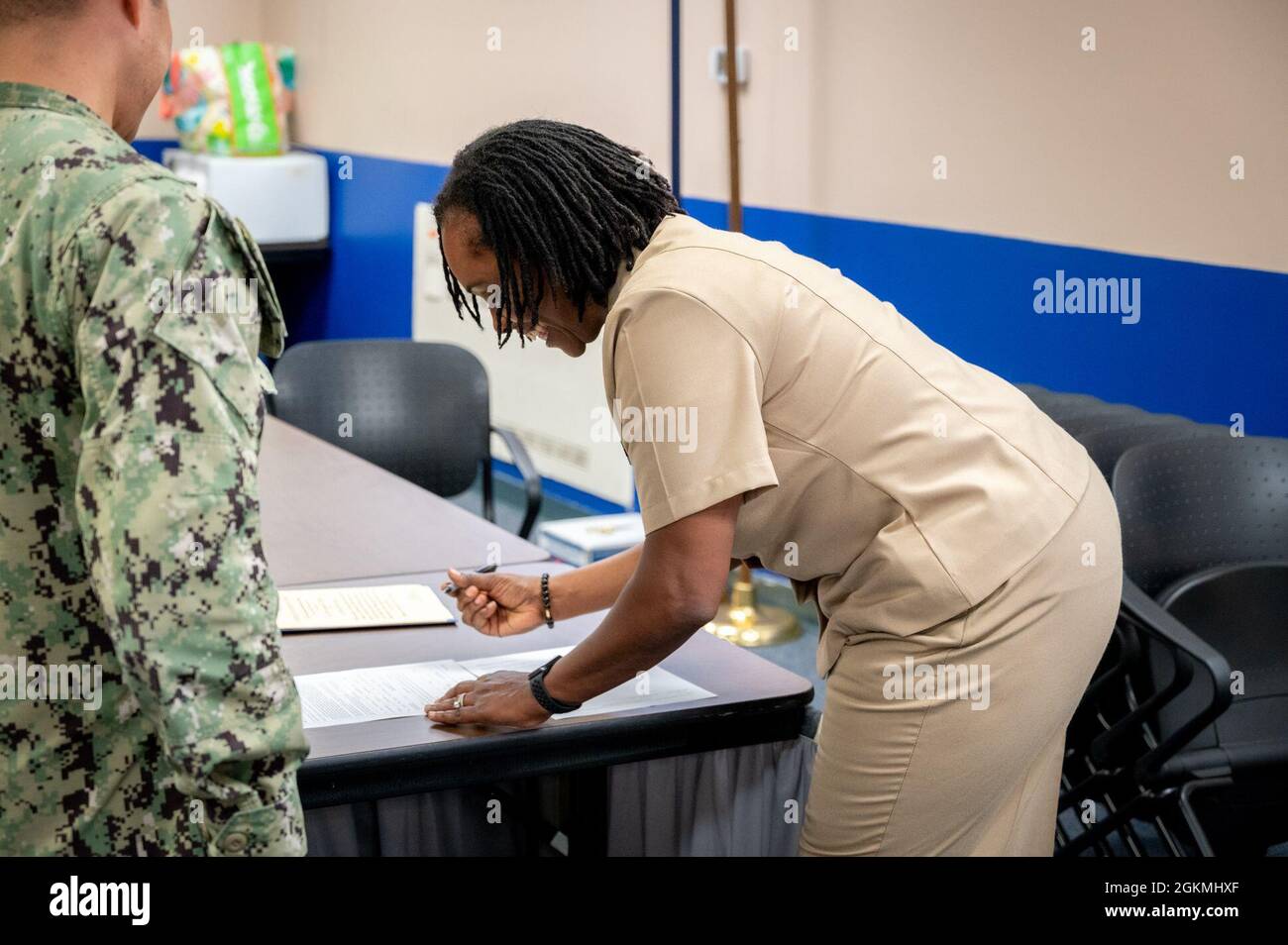 WASHINGTON, DC (May 27, 2021) – Lt. Takana Jefferson (left), Naval Support Activity Washington chaplain, signs reenlistment paperwork following a ceremony onboard Washington Navy Yard. Stock Photo