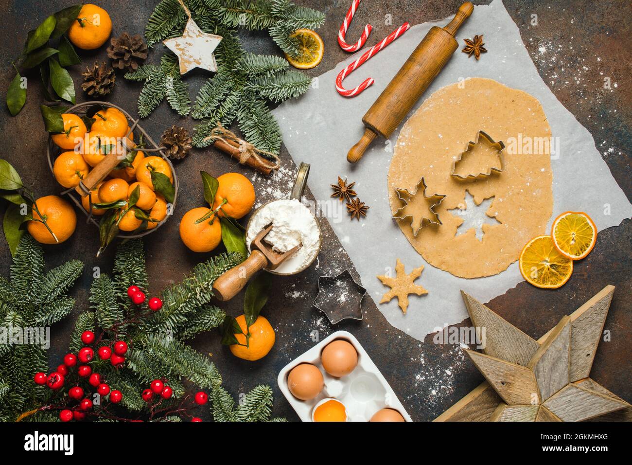 Holiday food. Ingredients for making Christmas ginger cookies small trees and snowflake. Mandarines, fir tree, candies. Stock Photo