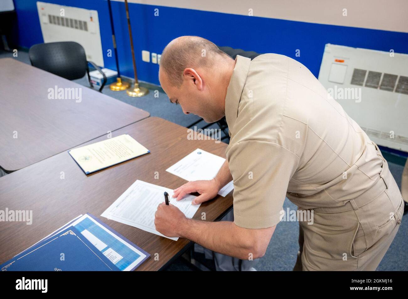 WASHINGTON, DC (May 27, 2021) – Chief Navy Counselor Eduardo Rivera signs reenlistment paperwork following a ceremony onboard Washington Navy Yard. Stock Photo